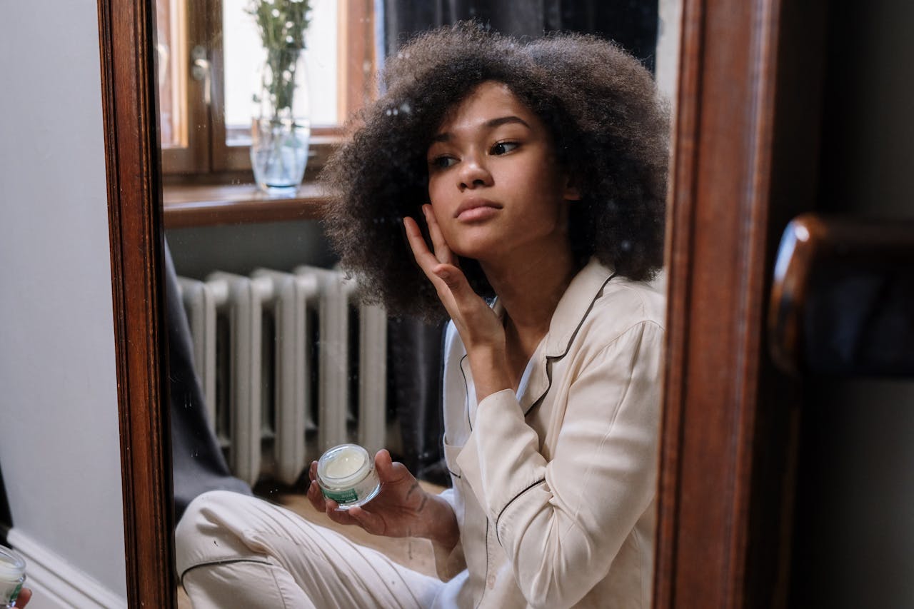 Woman applying facial cream at Home