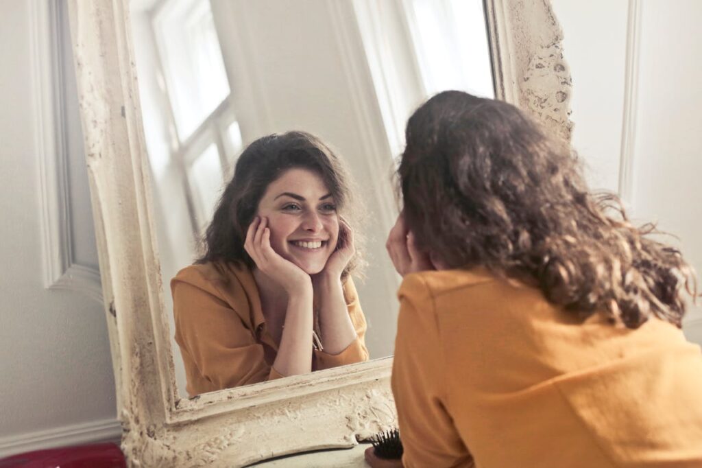 Woman staring in mirror happy with herself